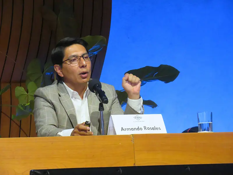 A person in a suit speaking into microphones

AI-generated content may be incorrect.